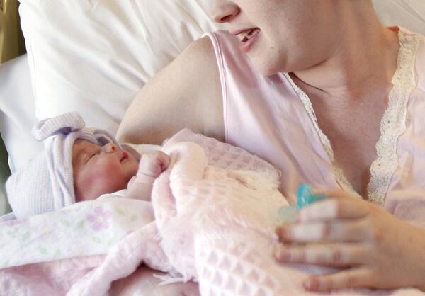 FILE - In this Friday, Nov. 11, 2011 file photo, a mother holds her newborn baby at a hospital in Corpus Christi, Texas. A study released Monday, Dec. 19, 2016 shows pregnancy affects not only a woman’s body: It changes parts of her brain structure too. (Michael Zamora/Corpus Christi Caller-Times via AP)