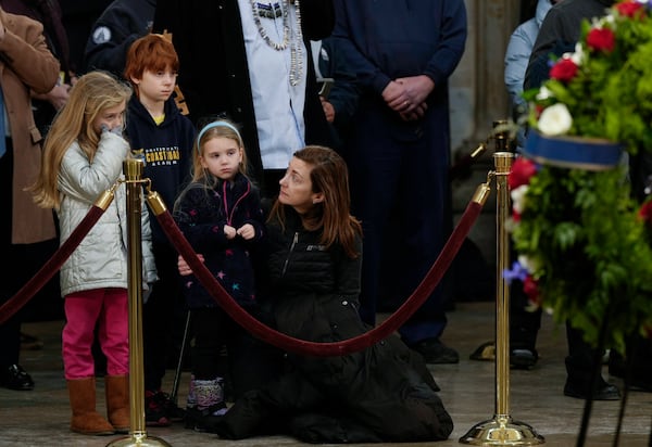 Jessica McClellan, right, along with her children, Louisa, 5, second from right, Abigail, 8, left, and Langston,10, second from left, of Potomac Md., pay their respects as the flag-draped casket of former President Jimmy Carter lies in state at the U.S. Capitol, Wednesday, Jan. 8, 2025, in Washington. Carter died Dec. 29 at the age of 100. (AP Photo/Steve Helber)