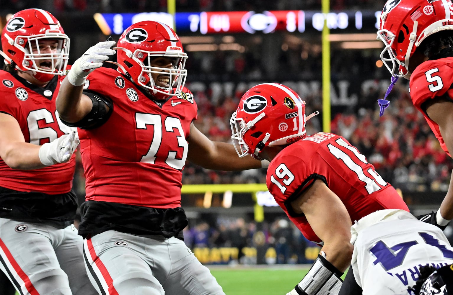 Georgia Bulldogs tight end Brock Bowers (19) celebrates with offensive lineman Xavier Truss (73) after a touchdown pass over TCU Horned Frogs safety Abraham Camara during the second half of the College Football Playoff National Championship at SoFi Stadium in Los Angeles on Monday, January 9, 2023. (Hyosub Shin / Hyosub.Shin@ajc.com)