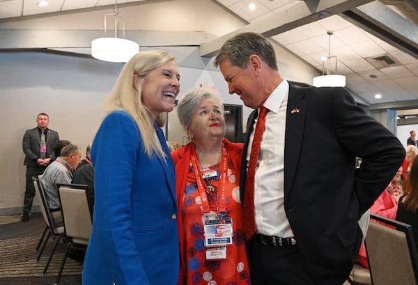 Gov. Brian Kemp and first lady Marty Kemp, left, are greeted by Nancy Burton, a GOP delegate from Walker County, before the governor spoke at the state delegation's breakfast on Tuesday. (Hyosub Shin / AJC)