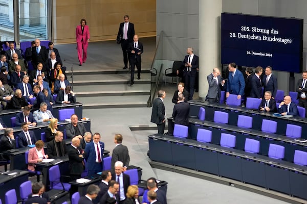 German Chancellor Olaf Scholz, centre arrives for a plenary session at the German parliament Bundestag where he faces a vote of confidence, Berlin, Germany, Monday, Dec. 16, 2024. (AP Photo/Markus Schreiber)