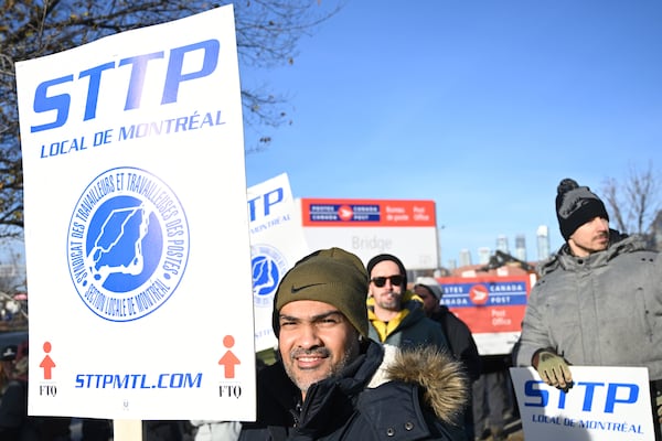 Canada Post workers picket outside a sorting plant in Montreal on Friday, Nov.15, 2024. (Graham Hughes/The Canadian Press via AP)