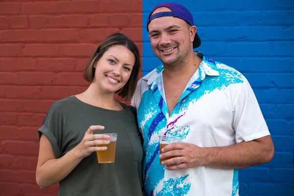 Caitlin Osterhaudt, 28, and her fiance, Sean Gray, 31, pose for a portrait with their beers on Food Truck Friday during the city’s weekly summertime bash, Fridays-N-Duluth, in downtown Duluth. (Casey Sykes for the Atlanta Journal-Constitution)