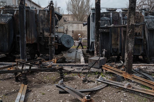 A worker of DTEK company walks in front of transformers of a substation destroyed by a Russian drone strike in undisclosed location, Ukraine, March 25, 2025. (AP Photo/Evgeniy Maloletka)