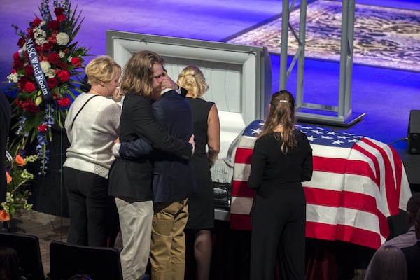 Dustin Walters, center left, hugs his brother Mason Walters, center right, during a funeral service for U.S. Navy Aircrewman Mechanical 3rd Class Cameron Walters at Compassion Christian Church in Savannah. Walters was one of the three sailors killed in the shooting this month at Naval Air Station Pensacola. (AJC Photo/Stephen B. Morton)