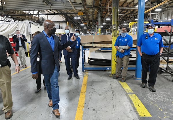 Sen. Raphael Warnock gives a thumbs up to workers during a tour of a Blue Bird school bus manufacturing facility in Fort Valley on Tuesday, May 4, 2021. (Hyosub Shin / Hyosub.Shin@ajc.com)