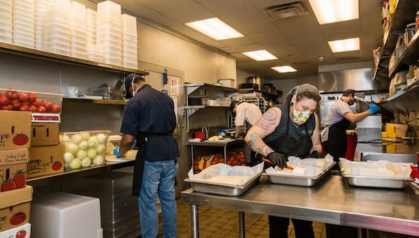 In the kitchen at Superica, pastry chef Daniela Canada, center, prepped tres leches cake while her colleagues prepped vegetables on March 25 for takeout orders. The next day, the restaurant shut down completely. (Jenni Girtman for The Atlanta Journal Constitution)