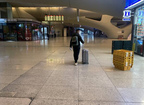 A passenger walks on Thursday, Jan. 23, 2020, through the railway station in Wuhan, China, where only a few passengers were debarking trains and residents were told that they could not board any. (Chris Buckley/The New York Times)