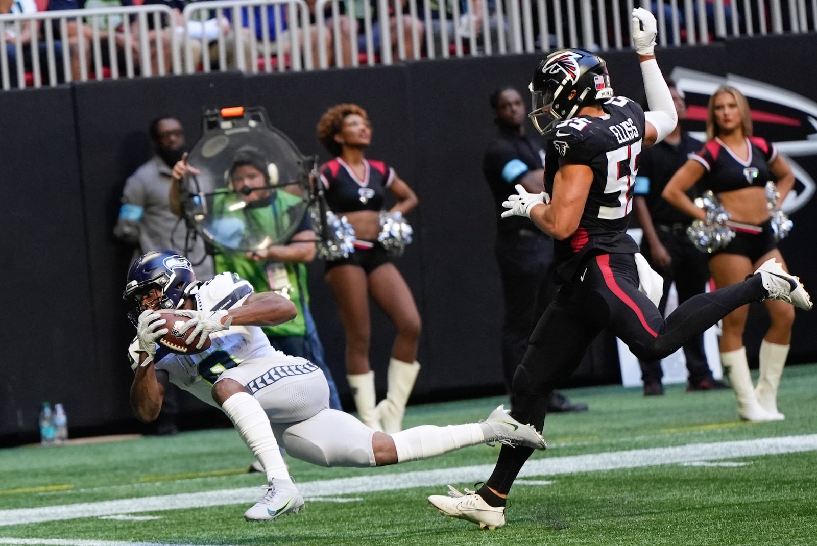 Seattle Seahawks running back Kenneth Walker III (9) scores a touchdown after a catch as Atlanta Falcons linebacker Kaden Elliss (55) defends during the second half of an NFL football game, Sunday, Oct. 20, 2024, in Atlanta. (AP Photo/ Mike Stewart)