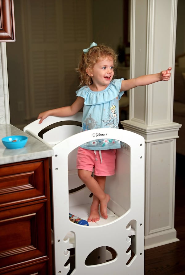 Ireland Tolbert eats dinner in a learning tower at her home. (JASON GETZ/SPECIAL TO THE AJC)