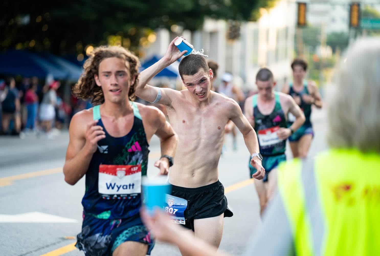 A runner dumps water on his head during the 55th running of The Atlanta Journal-Constitution Peachtree Road Race at "Cardiac Hill" on Peachtree Road NW in Atlanta on Thursday, July 4, 2024. (Seeger Gray / AJC)