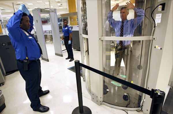 At Hartsfield-Jackson International Airport, a security system has been launched that can see items hidden under clothing without any physical contact from screeners. Here, Charles Jefferson (left) of the Transportation Security Administration demonstrates the use of the whole body imaging checkpoint technology.