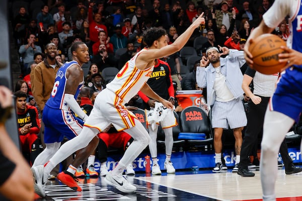 Hawks rookie Zaccharie Risacher reacts after a basket as teammate Trae Young celebrates from the bench.