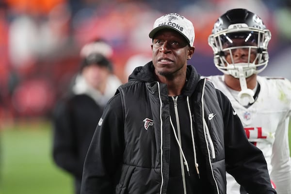 Atlanta Falcons head coach Raheem Morris, front, looks at the scoreboard as he leaves the field with wide receiver Darnell Mooney in tow after an NFL football game against the Denver Broncos, Sunday, Nov. 17, 2024, in Denver. (AP Photo/David Zalubowski)