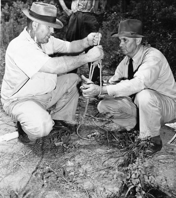 Loy Harrison (left), a witness to the Moore’s Ford murders, shows then-Sheriff J.M. Bond of Oconee County how a mob of white men bound the hands of two black men together before shooting them and their wives to death near Monroe, Ga., July 25, 1946. Authorities suspected that Harrison was complicit in the crime. (Associated Press Photo)