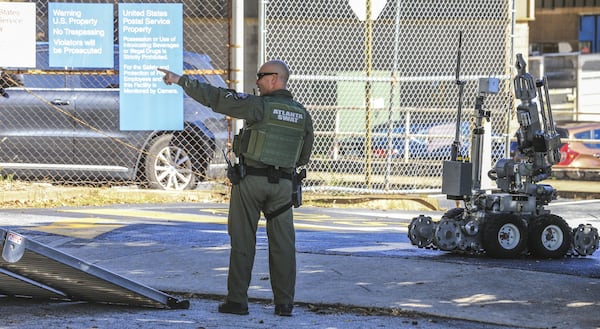 An Atlanta Police Bomb Squad officer readies the robot to depart after Atlanta police responded to a report of a suspicious package at the post office on 400 Pryor Street on Monday, according to department spokesman Officer Jarius Daugherty. The Atlanta Police Department’s bomb squad, FBI and the Bureau of Alcohol, Tobacco, Firearms and Explosives collected evidence at the scene. JOHN SPINK/JSPINK@AJC.COM