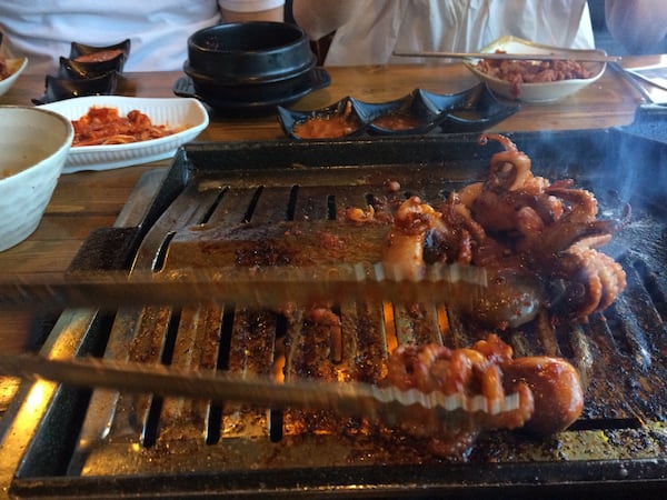 The tableside server-cook at K-BBQ Factory in Duluth grills spicy baby octopus. CONTRIBUTED BY WENDELL BROCK