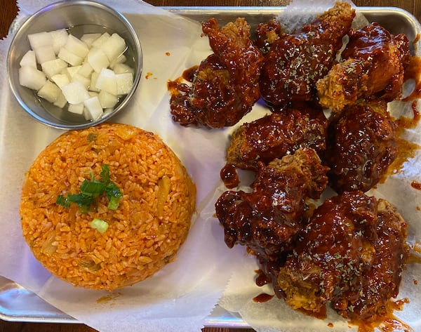 Chicken on Fire specializes in Korean-style fried chicken. Pictured is a chicken combo with jumbo wings, sweet-spicy sauce, kimchi fried rice and pickled radishes. (Ligaya Figueras/ligaya.figueras@ajc.com)