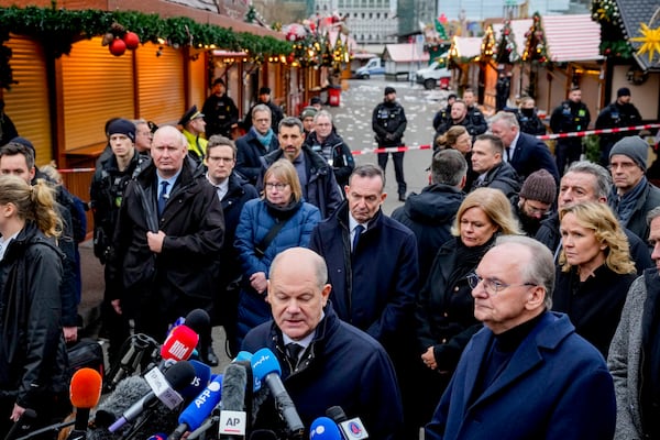 German Chancellor Olaf Scholz, centre, speaks at a Christmas Market, where a car drove into a crowd on Friday evening, in Magdeburg, Germany, Saturday, Dec. 21, 2024. (AP Photo/Michael Probst)