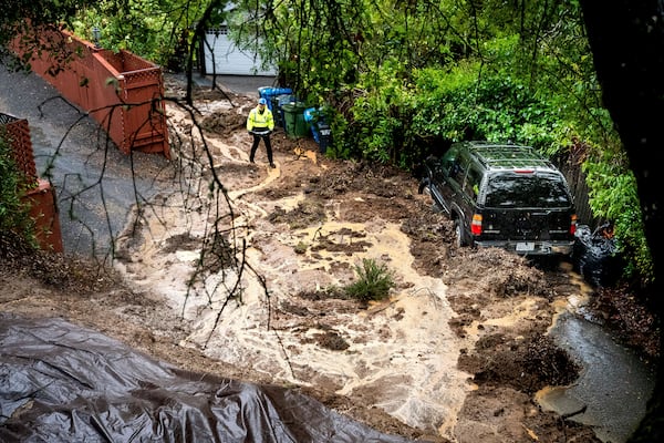 Permit Sonoma Director Tennis Wick crosses a mudslide to inspect a home as heavy rains fall near Healdsburg in unincorporated Sonoma County, Calif., on Friday, Nov. 22, 2024. (AP Photo/Noah Berger)