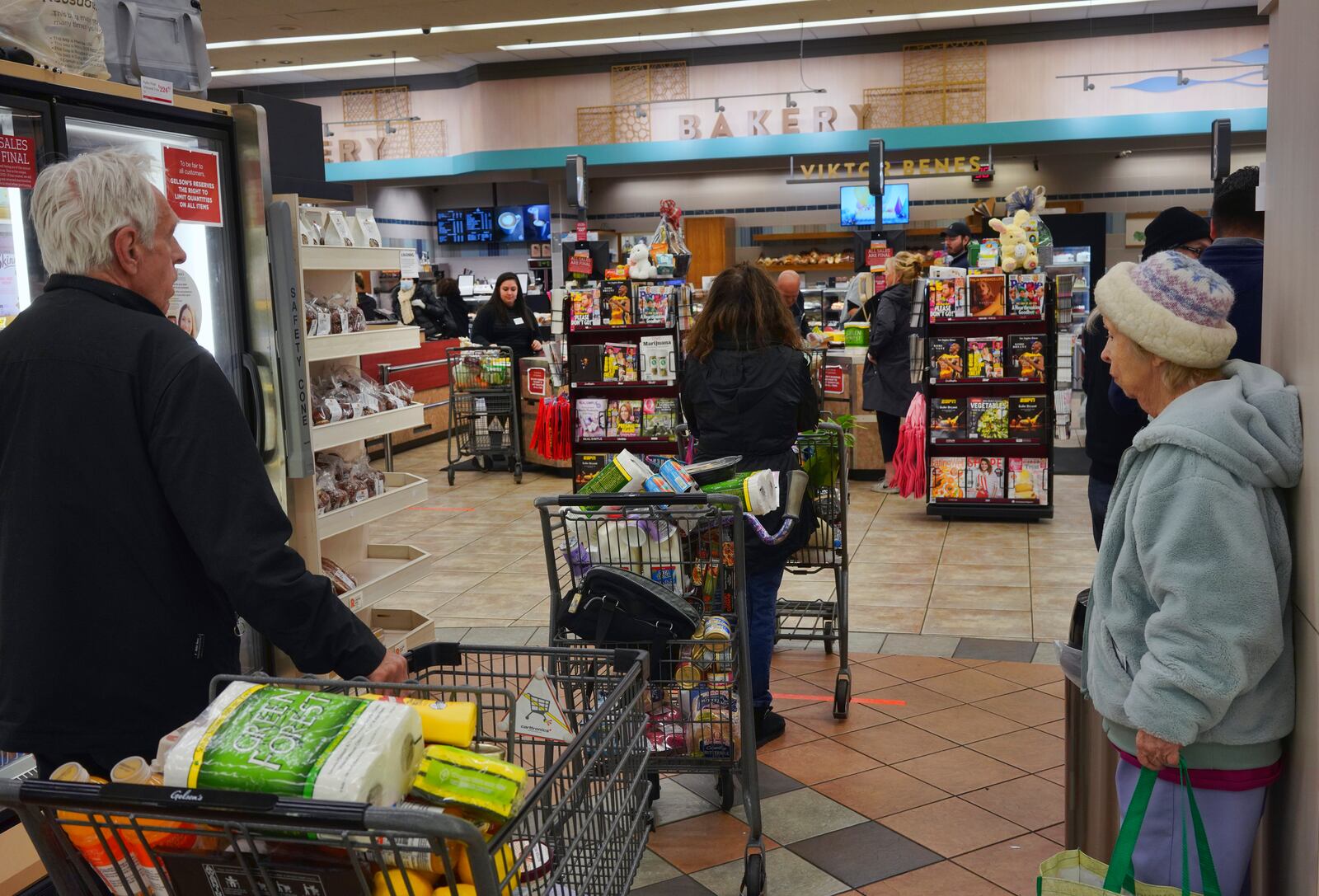 FILE - Shoppers wait in line to buy groceries at a Gelson's supermarket Friday, March 20, 2020, in the Sherman Oaks section of Los Angeles. (AP Photo/Richard Vogel, File)