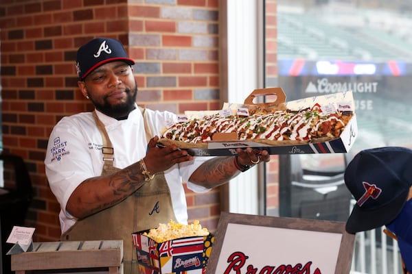 Sous-chef Chris Person holds the specialty food item Grand Slam Nacho during media day at Truist Park, Tuesday, March 26, 2024, in Atlanta. (Jason Getz / jason.getz@ajc.com)