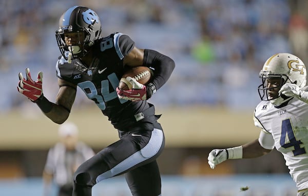 North Carolina's Bug Howard (84) runs the ball as Georgia Tech's Jamal Golden (4) chases during the first half of an NCAA college football game in Chapel Hill, N.C., Saturday, Oct. 18, 2014. Howard scored on the play. (AP Photo/Gerry Broome)