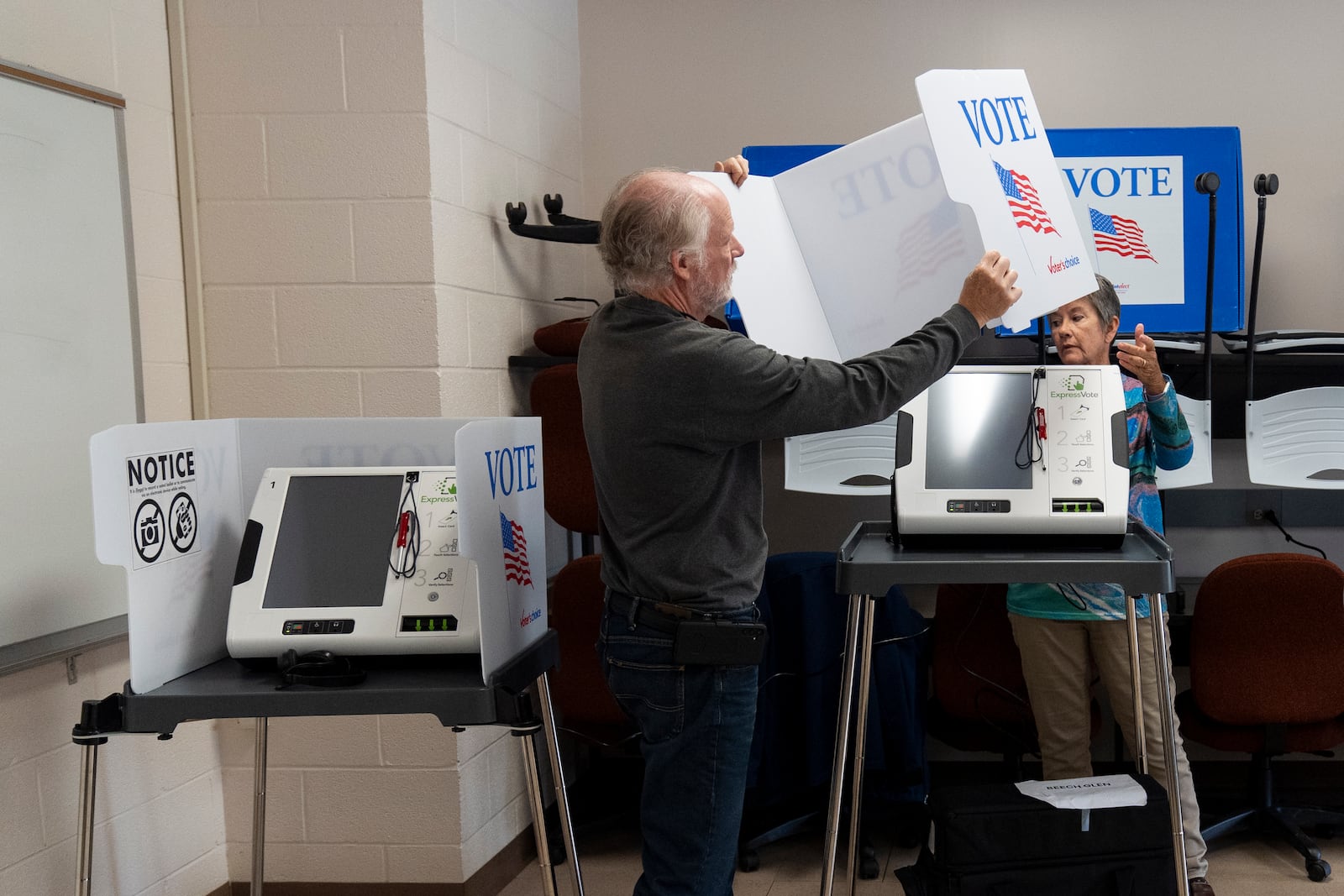 Poll workers set up ballot-marking machines at an early in-person voting site at Asheville-Buncombe Technical Community College, on Oct. 16, 2024, in Marshall, N.C. (AP Photo/Stephanie Scarbrough)