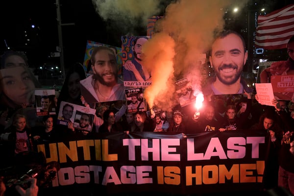 Demonstrators light flares as they gather during a protest calling for the release of all hostages held captive by Hamas in the Gaza Strip, in Tel Aviv, Israel on Saturday, Jan. 18, 2025. (AP Photo/Oded Balilty)