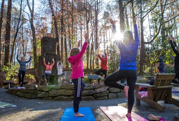 Marking the official beginning of winter, Dunwoody Nature Center holds an outdoor yoga class on the solstice where 8-year-old Kate McKeveny, left, and her mother, Linda McKeveny, right, participate in the hour-long class Monday, Dec 21, 2020.  (Jenni Girtman for The Atlanta Journal-Constitution)