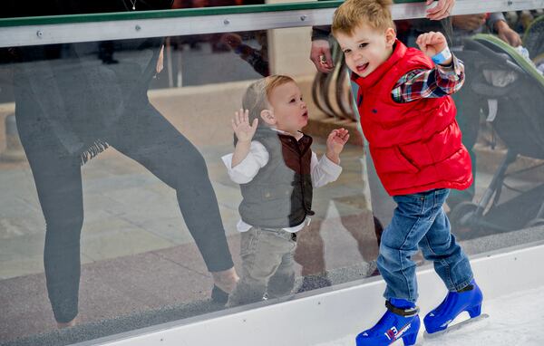 Barrett Pope (left) watches his older brother Wyatt skate on the ice rink at Avalon in Alpharetta on Sunday, Nov. 30, 2014. The rink will be open most days through February 2015. JONATHAN PHILLIPS / SPECIAL