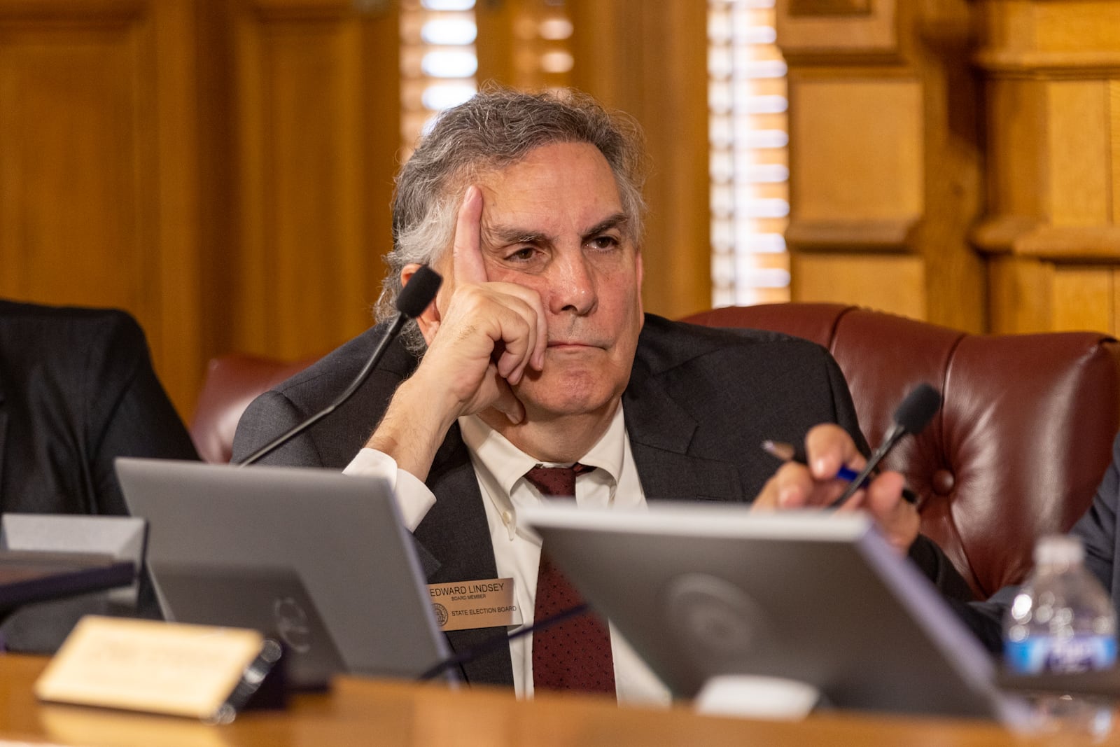 Ed Lindsey listens to people calling for his resignation during a State Election Board meeting in Atlanta earlier this month.