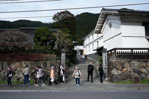 Visitors of Ozawa Sake Brewery leave as journalists enter the brewery on a media tour in Ome, on the western outskirts of Tokyo, Japan, Wednesday, Nov. 13, 2024. (AP Photo/Hiro Komae)