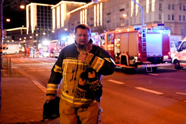 A firefighter walks through a cordoned-off area near a Christmas Market, after a car drove into a crowd in Magdeburg, Germany, Saturday, Dec. 21, 2024. (AP Photo/Ebrahim Noroozi)