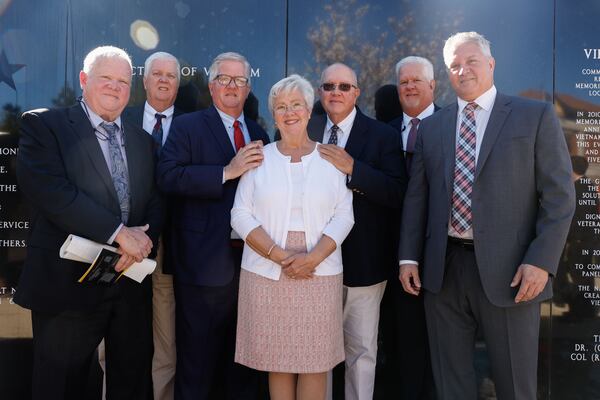 The children of William Callinan, who was killed in a helicopter crash during the Vietnam War, attended the dedication of the newly renovated Vietnam Veterans Memorial wall at the National Infantry Museum in Columbus on Friday, March 29, 2024. Margo Truett, center, stands with her brothers, left to right, Mike, Tom, Patrick, John, Danny and William Callinan Jr.  (Natrice Miller/ Natrice.miller@ajc.com)