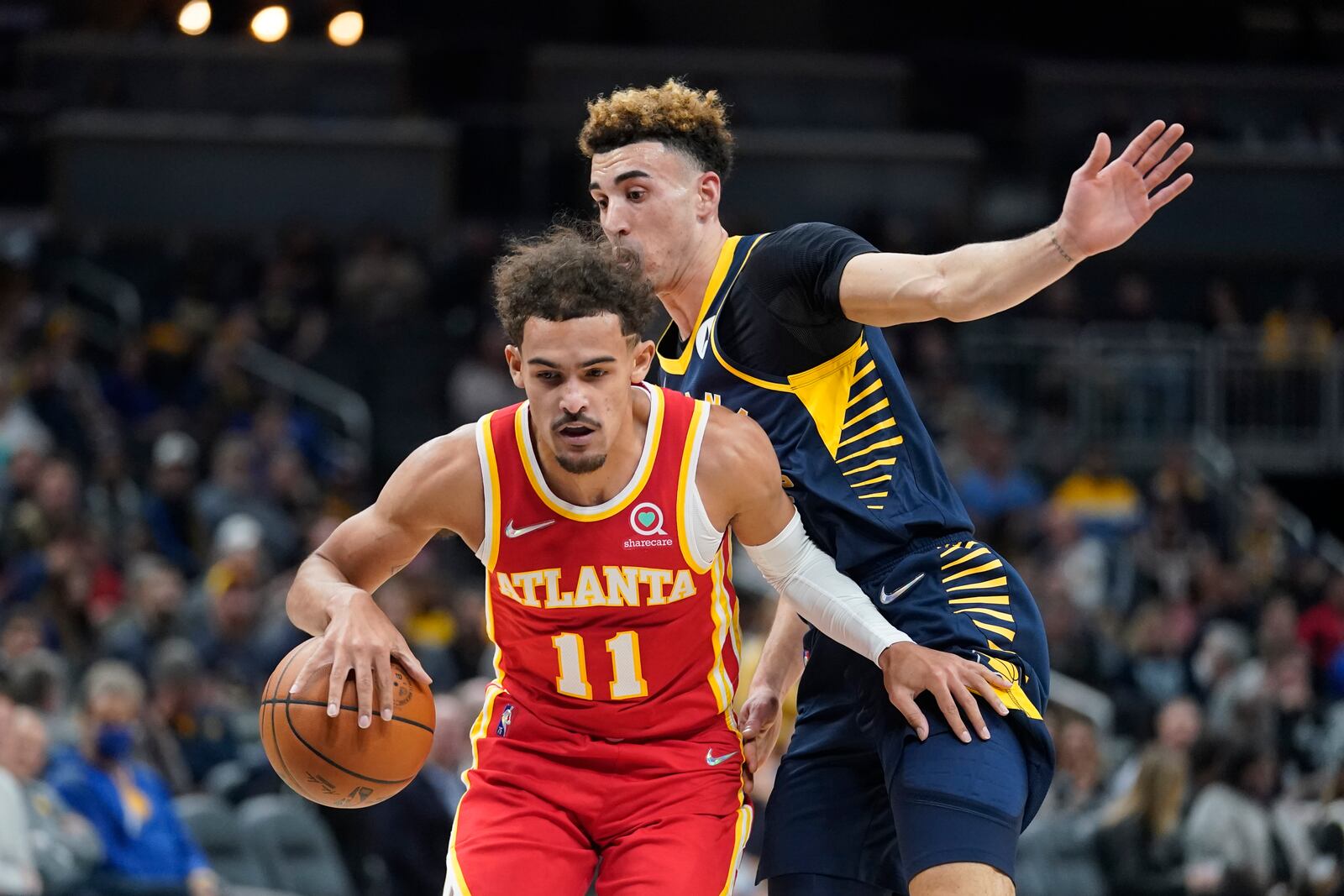 Atlanta Hawks' Trae Young (11) is defended by Indiana Pacers' Chris Duarte during the first half of an NBA basketball game Wednesday, Dec. 1, 2021, in Indianapolis. (AP Photo/Darron Cummings)