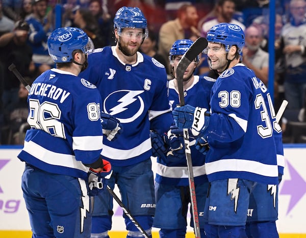 Tampa Bay Lightning right wing Nikita Kucherov (86), defenseman Victor Hedman (77), center Brayden Point (21), and left wing Brandon Hagel (38) celebrate after Point's goal during the second period of an NHL hockey game against the Colorado Avalanche, Monday, Nov. 25, 2024, in Tampa, Fla. (AP Photo/Jason Behnken)