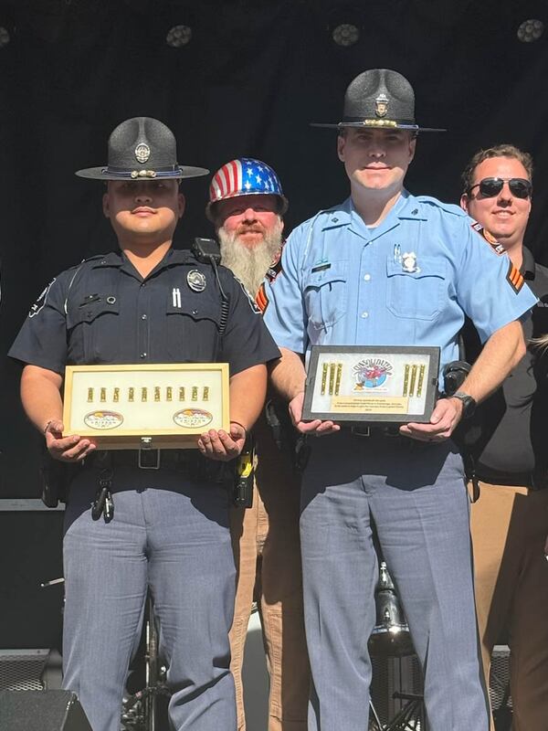 Sgt. Brent Sanford, a Georgia state trooper, and Officer Chin Pan, a Georgia Capitol police officer, hold 10 ounces of Dahlonega gold Saturday. The donated gold is be transported to Atlanta for the regilding of the Capitol dome. Courtesy of Patrick Quirk.