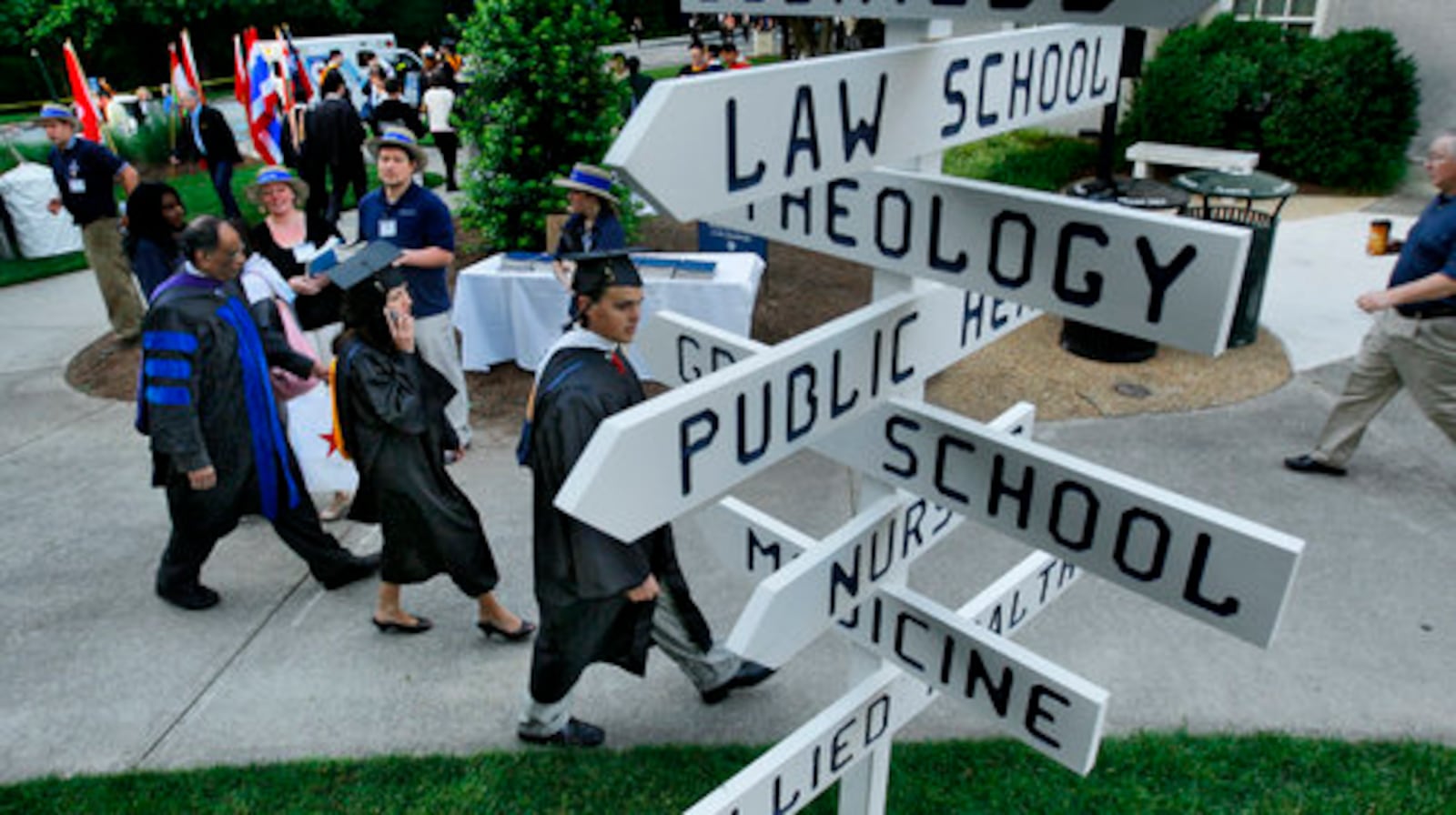 Graduates move into place Monday for graduation ceremonies at Emory University as signs point the way Commencement took place on the Emory quadrangle for about 3,900 graduates. About 15,000 people attended.