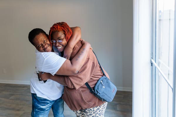 Synya Bradshaw, 52, and Maria Hairston, 35, who were previously unhoused, embrace during a portrait in their new apartment in Jonesboro on Thursday, November 3, 2022.   (Arvin Temkar / arvin.temkar@ajc.com)