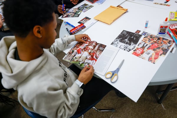 Redan High School student Montravious Favors works on his vision board during an end-of-year group project in Stone Mountain on Tuesday, May 14, 2024. The DeKalb County School District has placed one-on-one mentors at some schools this year to help improve students' attendance, behavior and academic performance. (Steve Schaefer / AJC)