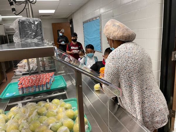 Pupils at Lake City Elementary School pick up breakfast on Aug. 2, 2021, the first day of classes. (Leon Stafford / AJC)