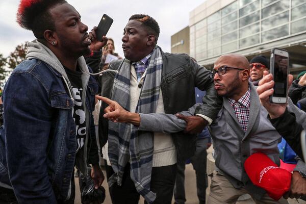 President Donald Trump supporters Tony Smith (right) of College Park and Jerrod Brown (center) of Savannah, get in a verbal shouting match with Anti-Trump protestor Chris Mungin (left) near the Georgia World Congress Center, Friday, November 8, 2019. (Alyssa Pointer)