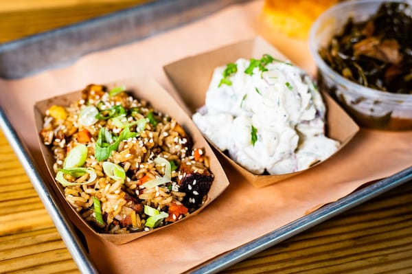 Side dishes at Wood’s Chapel BBQ, from left: pork-belly fried rice, buttermilk and dill potato salad, braised greens and a hunk of cornbread. CONTRIBUTED BY HENRI HOLLIS