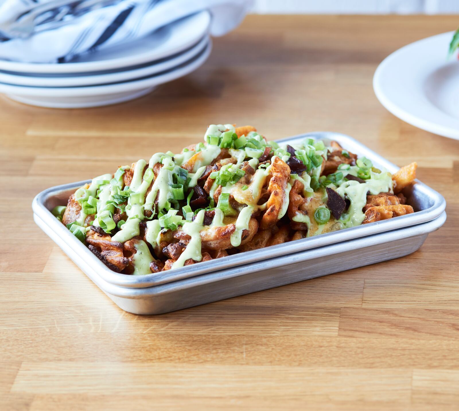 Emmy Squared’s Zia fries are waffle spuds loaded with Hatch pimento cheese, scallions, bacon and ranch. (Courtesy of Emmy Squared Pizza)