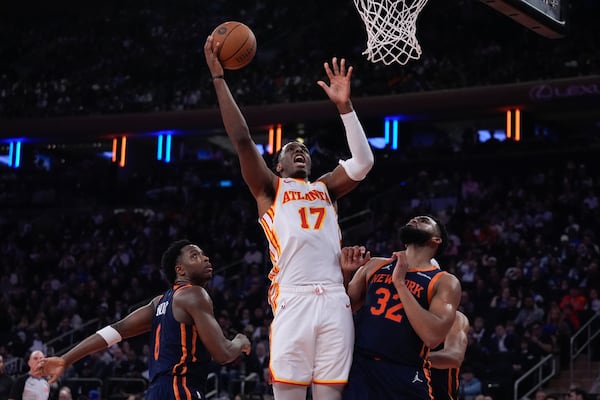 Atlanta Hawks' Onyeka Okongwu (17) shoots over New York Knicks' Karl-Anthony Towns (32) and OG Anunoby (8) during the first half of an Emirates NBA Cup basketball game Wednesday, Dec. 11, 2024, in New York. (AP Photo/Frank Franklin II)