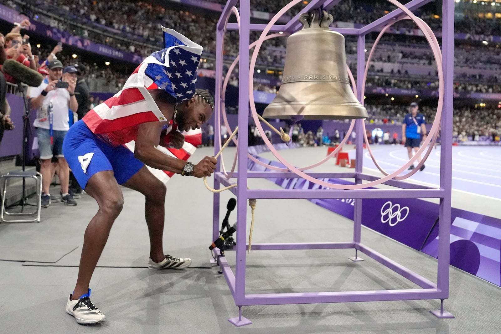 FILE - Noah Lyles, of the United States, celebrates after winning the men's 100-meters final by ringing the bell at the 2024 Summer Olympics, Sunday, Aug. 4, 2024, in Saint-Denis, France. (AP Photo/Matthias Schrader, File)