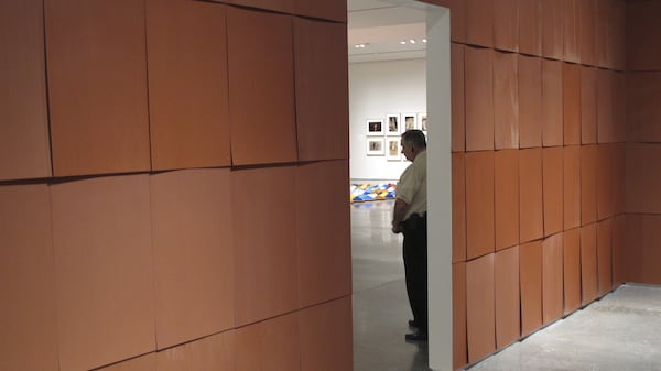 In this Aug. 30, 2017 photo, a guard stands outside the ''Chocolate Room'' by American artist Ed Ruscha on display in the exhibit ''Unsettled'' at the Nevada Museum of Art in Reno, Nev. The room made from sweet-smelling chocolate shingles is the fifth version of Ruscha's work since it debuted at the 1970 Venice Biennale in Italy. (AP Photo/Scott Sonner)