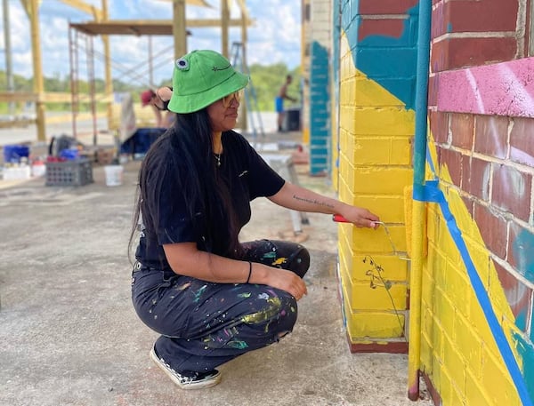 A local artist paints the side of building located at Triangle Arts, a Macon arts incubator. (Courtesy of Triangle Arts Macon)