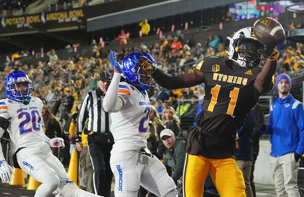 Wyoming wide receiver Justin Stevenson, right, misses a pass in the end zone as Boise State safety Zion Washington, center, and cornerback Davon Banks defend in the first half of an NCAA college football game Saturday, Nov. 23, 2024, in Laramie, Wyo. (AP Photo/David Zalubowski)